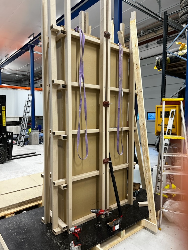 En uppsättning av trästommar och stöd som används för konstruktion, med verktyg och material placerade i en verkstadsmiljö.