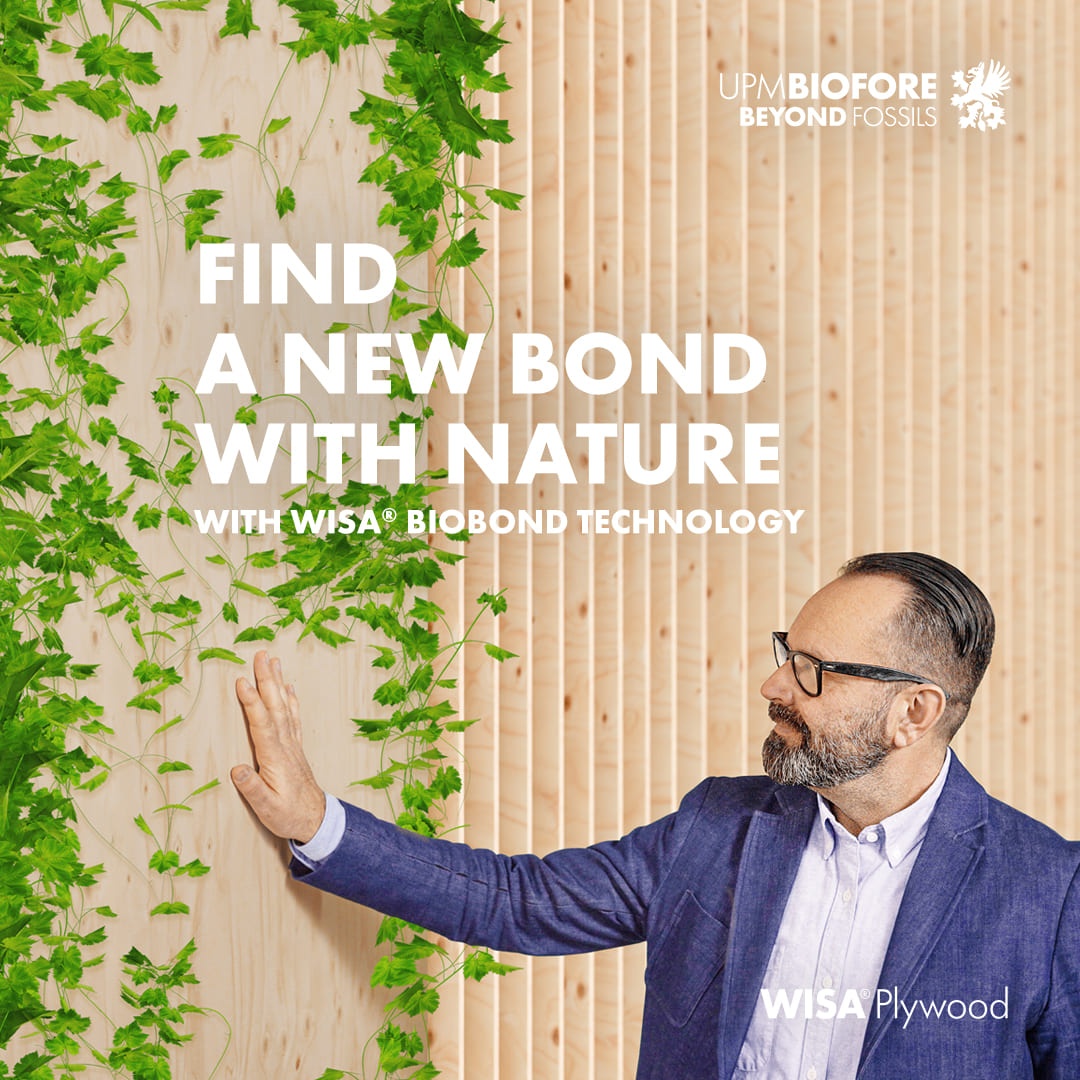 En man i glasögon rör vid en vägg av trä med gröna växter som klättrar uppåt. Texten &quot;Find a new bond with nature&quot; i samband med WISA® Biobond-teknologi är synlig.