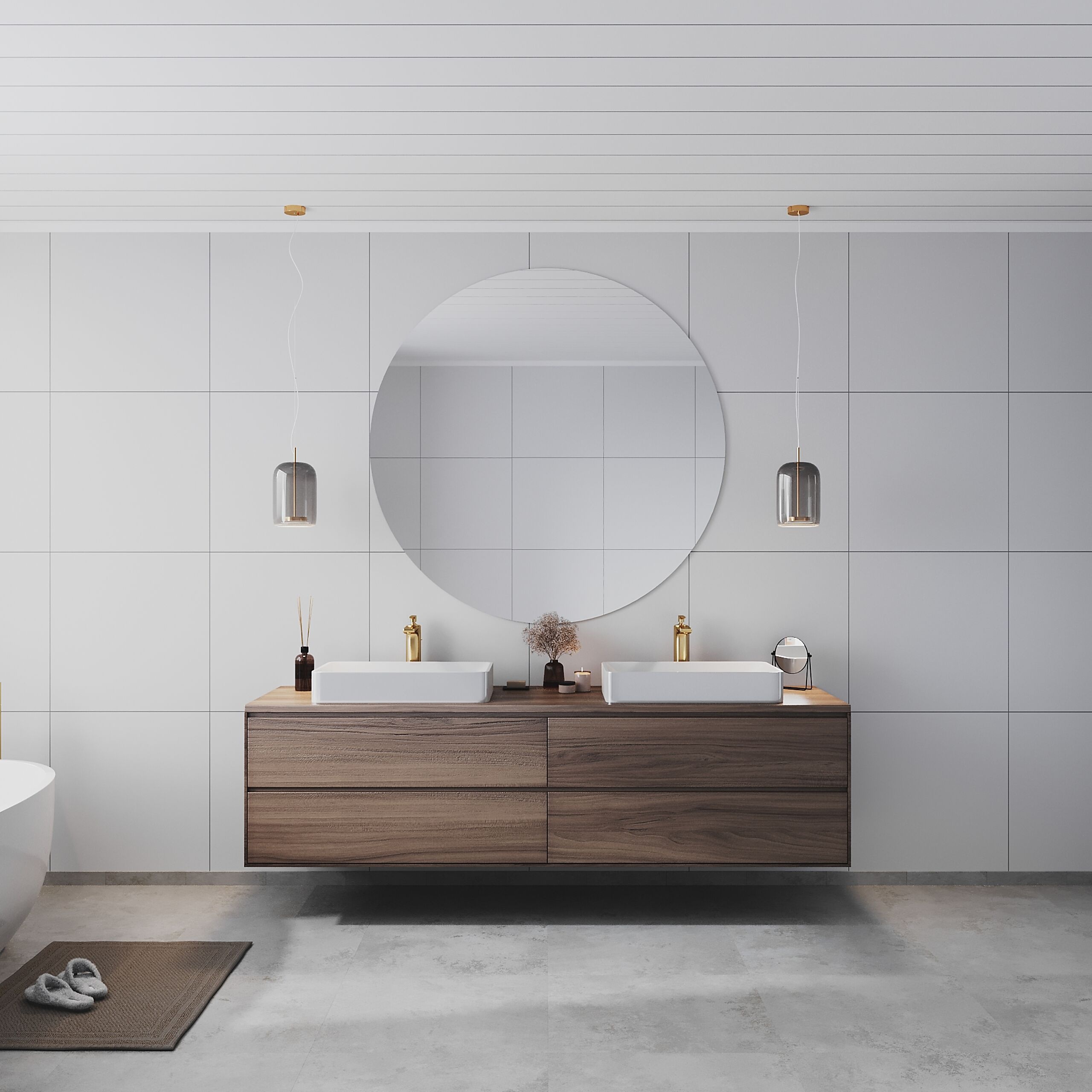 Modernt badrum med en stor spegel och två handfat på en träkommod. Grå plattor på väggarna och en golvmatta i mörkgråa toner. Läckra hängande lampor ger mjukt ljus.